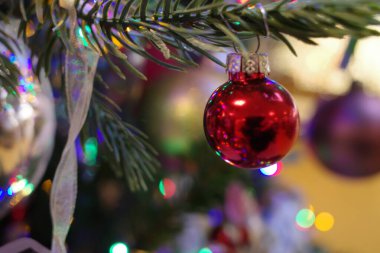 Kırmızı bir Noel ağacının arka planında bulanık bir mücevher.
