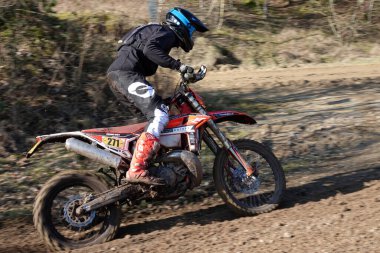 Wilsum, Almanya - 2 Mart 2025 Alman Enduro Mastery katılımcısı çamurlu bir yolda son sürat gidiyor