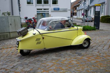 Bad Bentheim, Almanya - 4 Mayıs 2025 tatlı sarı bir Messersmitt Kabinroller 1958 'den KR200 Bad Bentheim' deki klasik araba toplantısından uzaklaşıyor