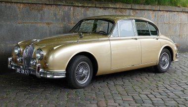 Bad Bentheim, Almanya - 4 Mayıs 2025 Altın Jaguar Mark 2 'nin önü - 3.4 L 1965. Eski bir caddeye park edilmiş.