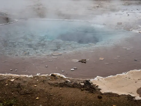 Steaming colorful hot spring pool in Geysir geothermal area, Iceland