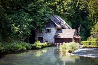 Hırvatistan 'ın Slunjcica nehrinin kıyısındaki ormanlarda gizlenmiş güzel taş ev