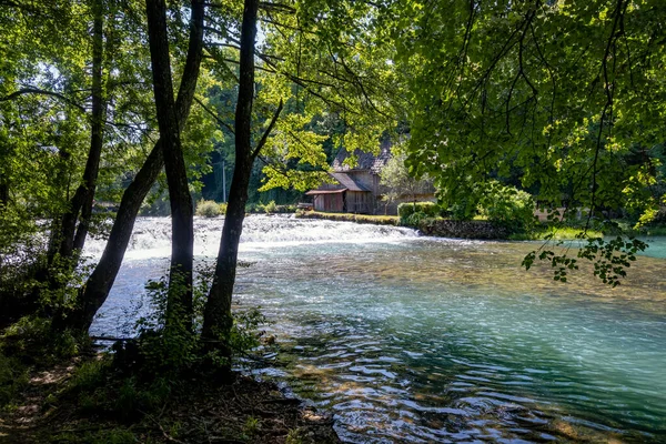 stock image Old cottage hidden in the beautiful, green forest on the shore of Slunjcica river near the famous Rastoke waterfalls, Croatia