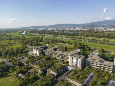 Zagreb, Croatia-September 26th, 2023: Aerial view of abandoned and overgrown hospital centre, overtaken by nature and growing vegetation on the Sava river embankment in Zagreb city, Croatia clipart
