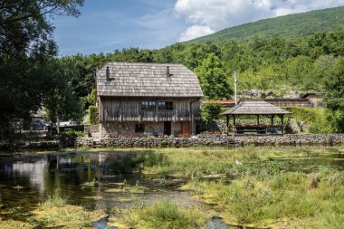 Sinac, Hırvatistan-29 Haziran 2024: Muhteşem Majerovo Vrilo, Hırvatistan 'ın Sinac kasabasında Gacka nehir kaynağı etrafında inşa edilen eski değirmen evleri ve köprüler