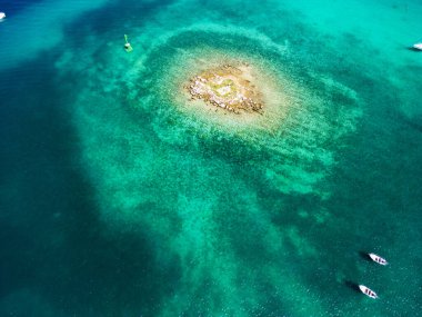 Hırvatistan 'ın Rogoznica körfezindeki sığ denizle çevrili küçük kaya adasının havadan aşağı manzarası