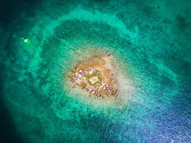 Hırvatistan 'ın Rogoznica körfezindeki sığ denizle çevrili küçük kaya adasının havadan aşağı manzarası