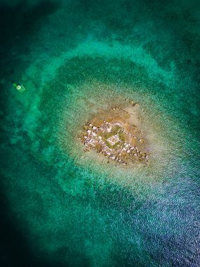 Hırvatistan 'ın Rogoznica körfezindeki sığ denizle çevrili küçük kaya adasının havadan aşağı manzarası