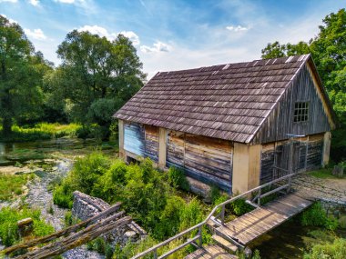 Hırvatistan 'ın Sinac kasabasındaki Muhteşem Majerovo Vrilo ahşap evleri ve Gacka nehir kaynağının hava görüntüsü
