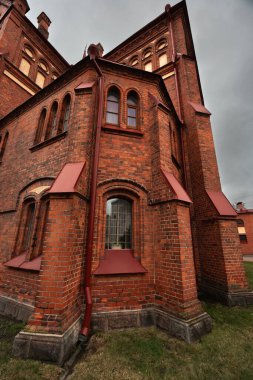Katolik kilisesi ilkbahar sabahının erken saatlerinde kırmızı tuğlalarla, bulutlu gökyüzü, saat kulesi, yağmurlu hava. Bakire Meryem Katedrali mi yoksa Meryem Ana Katedrali mi?.
