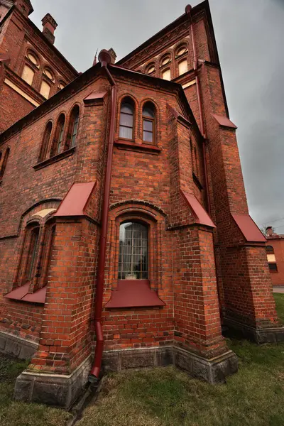 Katolik kilisesi ilkbahar sabahının erken saatlerinde kırmızı tuğlalarla, bulutlu gökyüzü, saat kulesi, yağmurlu hava. Bakire Meryem Katedrali mi yoksa Meryem Ana Katedrali mi?.