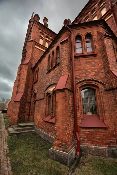 Katolik kilisesi ilkbahar sabahının erken saatlerinde kırmızı tuğlalarla, bulutlu gökyüzü, saat kulesi, yağmurlu hava. Bakire Meryem Katedrali mi yoksa Meryem Ana Katedrali mi?.