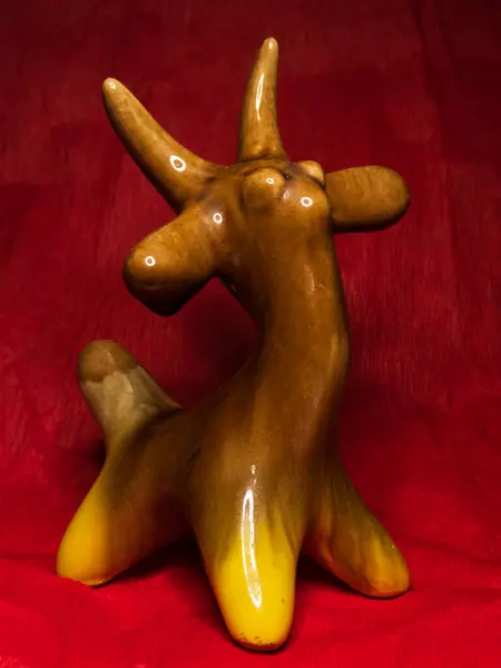 Görsel ve sanatsal bir izlenim yaratan, çarpıcı bir kırmızı arkaplana yerleştirilmiş, modern ve soyut bir tona sahip eşsiz bir seramik sanat eseri..