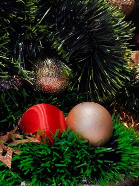 Yeşiller arasında kırmızı ve altın takıların yer aldığı Noel süslemeleri, şenlikli ve bayram temalı bir atmosfer yaratıyor..