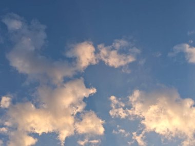 Açık Mavi Gökyüzüne karşı Altın Beyaz Bulutlar.