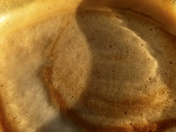 Bir fincan kahvenin köpüklü yüzeyi.