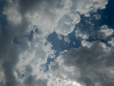 Parlak mavi gökyüzüne karşı karanlık ve aydınlık bulutlar..