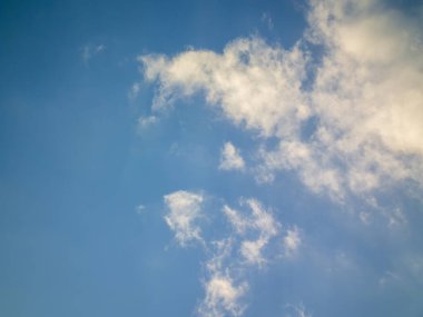 Güneşli bir günde kümülüs ve sirrus bulutlarıyla dinamik bir gökyüzü..