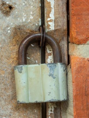 Antika, kırsal asma kilit. Paslanmış ve soyulmuş boya detaylarını gösteriyor..