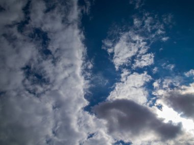 Parlak beyaz ve tehditkar kara bulutlarla dolu masmavi gökyüzü