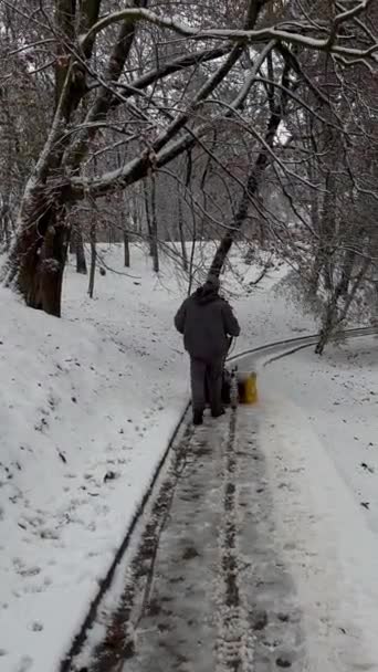 Człowiek Dozorca Sprząta Śnieg Drodze Parku Miejskiego Szczotką Elektryczną — Wideo stockowe