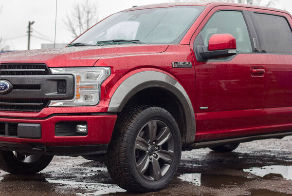 Lviv Ukraine - 12242022: Ford F-150 display red at the dealership. Ford F150 is available  XL, XLT, Lariat, King Ranch, Platinum and Limited models.SUV Ford F150 Platinum in the parking lot  in rainy