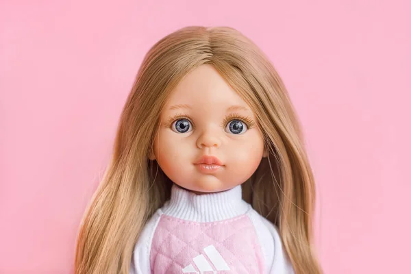 Doll with beautiful blond hair and a cute face close-up portrait, sale of children\'s toys, doll fashion, selective focus