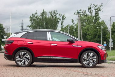 Lviv Ukrayna - 06 11 2023: Kırmızı volkswagen elektrikli araba şehrin otoparkında, çevre dostu modern araba