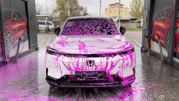リヴィウクライナ 2023 セルフサービスの車の洗浄でピンクの泡のホワイトホンダの電気自動車 — ストック動画