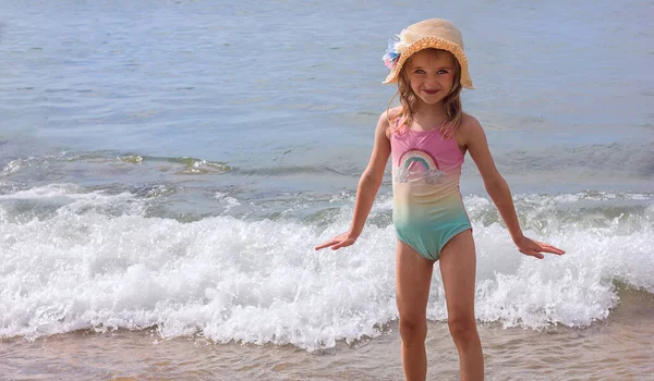 明るい晴れた日には 海の背景に明るい水着と帽子の美しい少女は 選択的な焦点 ストック写真
