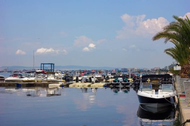 Körfezde yatlar, motorlu tekneler ve katamaranlar güzel bir deniz manzarasına karşı.