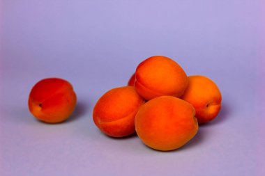 Mor arka planda taze turuncu kayısılar.