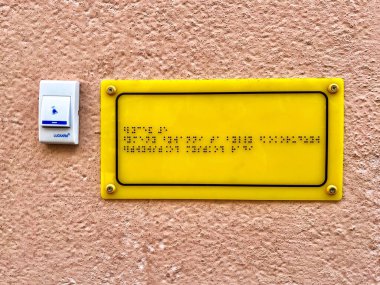 Lviv Ukrayna - 07 - 4 2025: Bir okul eğitim kurumunun duvarında Braille işareti ve çağrı tuşu, engelli insanlara yardım
