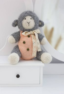 Tığ işi amigurumi oyuncak koyun kuzu beyaz arka planda, el yapımı oyuncaklar.