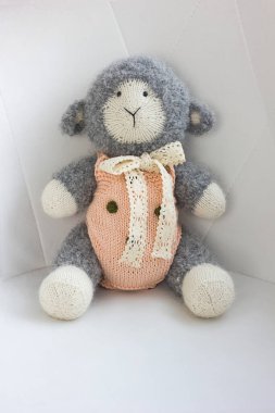 Tığ işi amigurumi oyuncak koyun kuzu beyaz arka planda, el yapımı oyuncaklar.