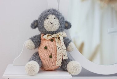 Tığ işi amigurumi oyuncak koyun kuzu beyaz arka planda, el yapımı oyuncaklar.