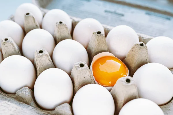白い殻の卵と再生段ボールトレイに黄身と1つの壊れた卵のトップビュー 多様性個性健康的な食べ物 — ストック写真