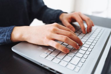 Kadın elleri dizüstü bilgisayarın klavyesinde. Dizüstü bilgisayar klavyesinde yazı yazan kadın ellerinin yakın çekimi. Bilgisayar kullanan genç bir kadın..