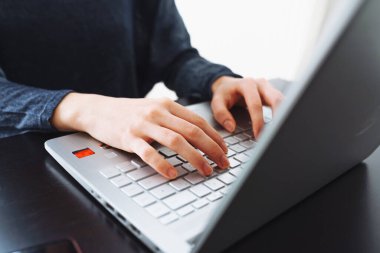 Kadın elleri dizüstü bilgisayarın klavyesinde. Dizüstü bilgisayar klavyesinde yazı yazan kadın ellerinin yakın çekimi. Bilgisayar kullanan genç bir kadın..