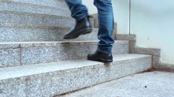 ジーンズ 冬の黒いブーツ 冬のジャケットの脚の登山 花崗岩の灰色の階段を登る 高品質4K映像 — ストック動画