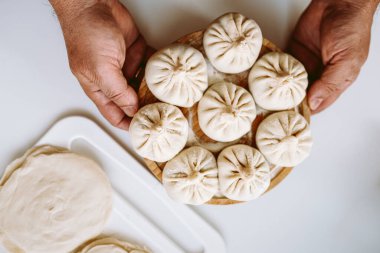 Eller ahşap ahşap tahtayı un, el yapımı khinkali ile pişirir.