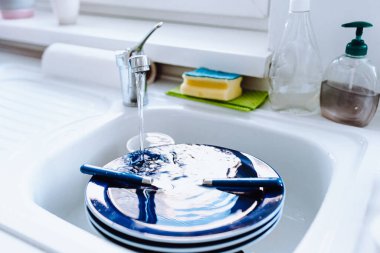 Mutfak, kirli bulaşıklarla dolu beyaz cephelerle dolu. Elle bulaşık yıkama konsepti.