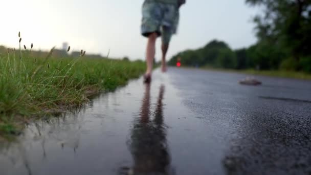 少女的腿 少女的腿 在日落时赤脚跑过水坑 在雨中 在雨中赤脚跑过水坑 与自然合一 腿健康的概念 — 图库视频影像
