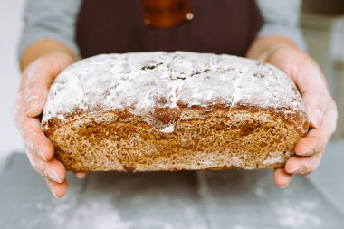 Dikdörtgen şeklinde çavdar ekmeği serpiştiren kadın şefin elleri.
