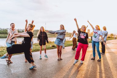 Parti orta yaşlı kadınlar, milenyum, gün batımında. Grup dansı, neşeli, çekici, mutlu kadınlar, yaz, tatil, seyahat. Gün batımında dans eden neşeli ve çekici kadınlar. 