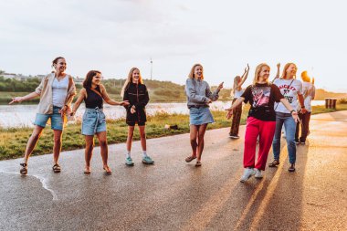 Parti orta yaşlı kadınlar, milenyum, gün batımında. Grup dansı, neşeli, çekici, mutlu kadınlar, yaz, tatil, seyahat. Gün batımında dans eden neşeli ve çekici kadınlar. 