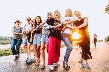 Parti orta yaşlı kadınlar, milenyum, gün batımında. Grup dansı, neşeli, çekici, mutlu kadınlar, yaz, tatil, seyahat. Gün batımında dans eden neşeli ve çekici kadınlar. 