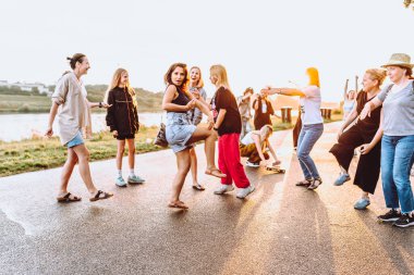 Parti orta yaşlı kadınlar, milenyum, gün batımında. Grup dansı, neşeli, çekici, mutlu kadınlar, yaz, tatil, seyahat. Gün batımında dans eden neşeli ve çekici kadınlar. 