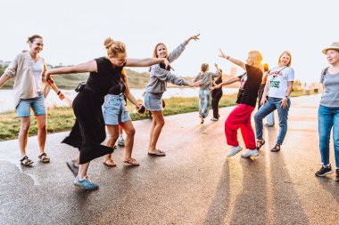 Parti orta yaşlı kadınlar, milenyum, gün batımında. Grup dansı, neşeli, çekici, mutlu kadınlar, yaz, tatil, seyahat. Gün batımında dans eden neşeli ve çekici kadınlar. 