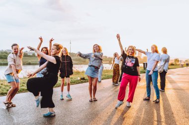 Parti orta yaşlı kadınlar, milenyum, gün batımında. Grup dansı, neşeli, çekici, mutlu kadınlar, yaz, tatil, seyahat. Gün batımında dans eden neşeli ve çekici kadınlar. 